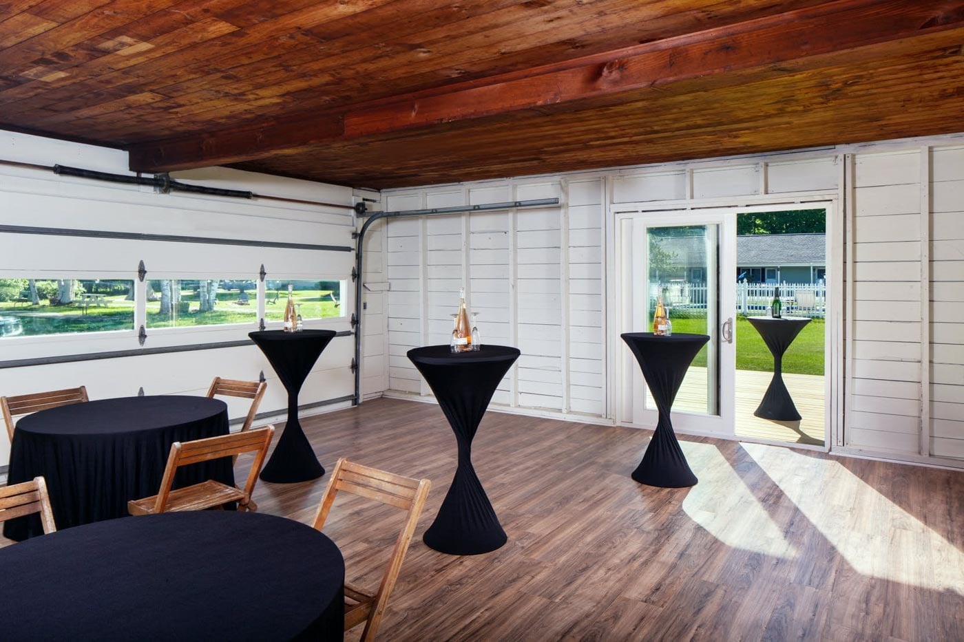 A room with tables and chairs in a garage.