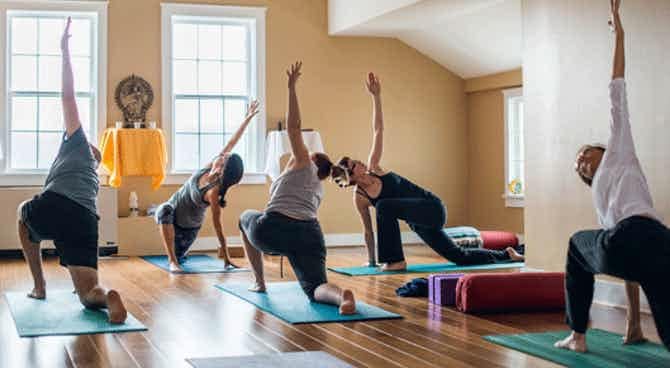 A group of people doing yoga in a room.